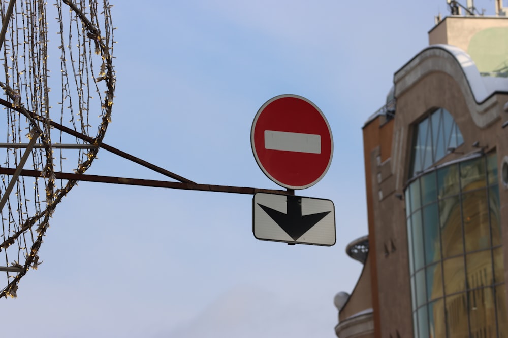 a red and white street sign next to a tall building