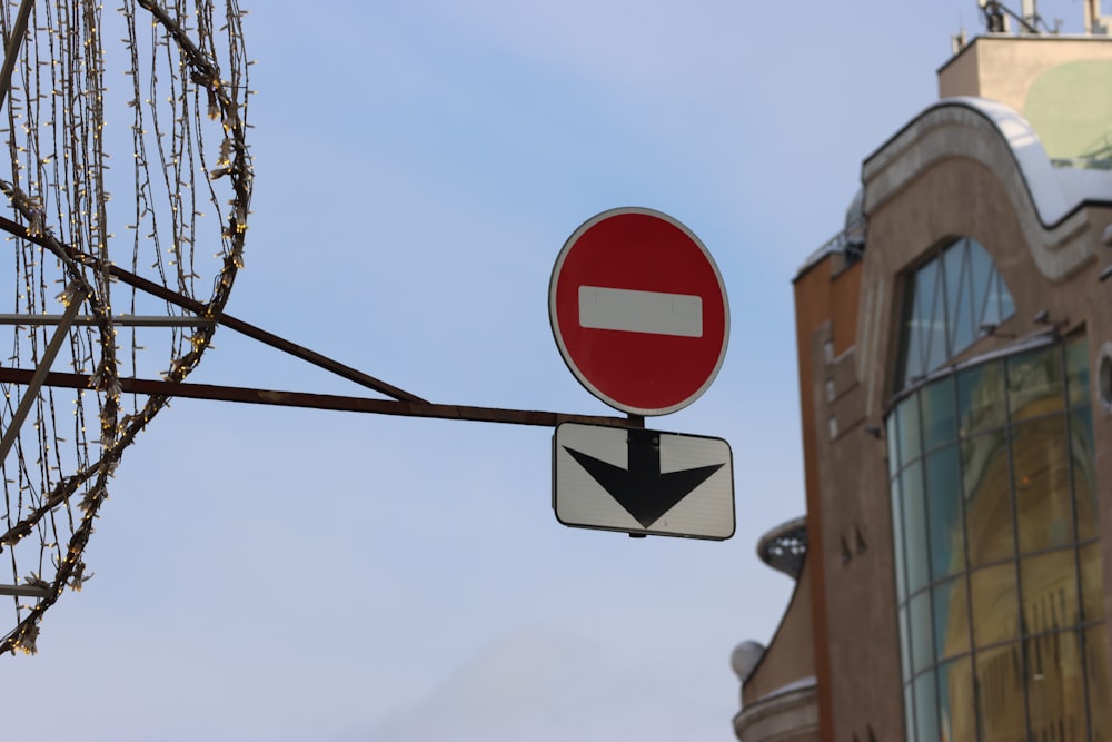 ein rot-weißes Straßenschild neben einem hohen Gebäude