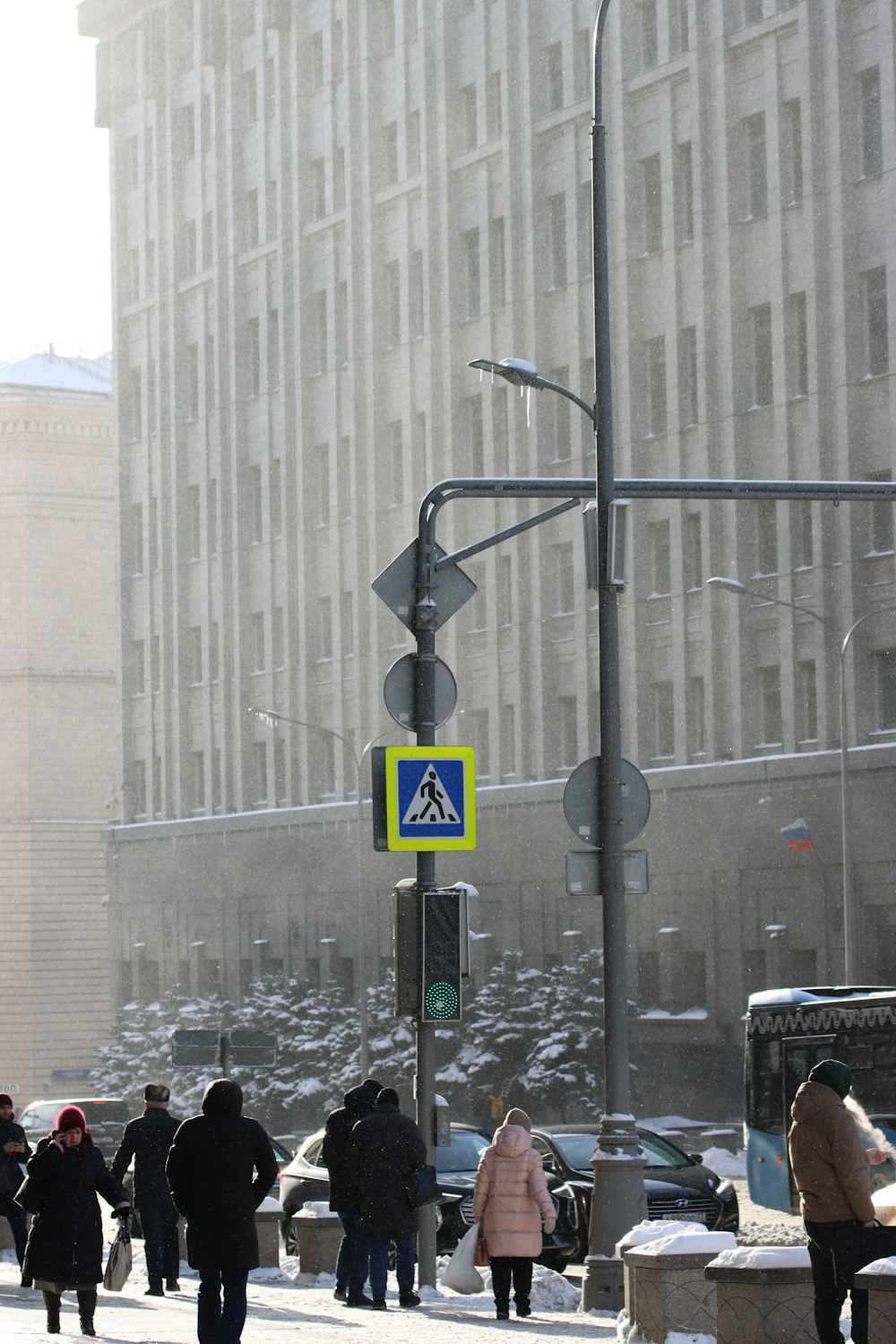 a group of people walking down a street next to tall buildings