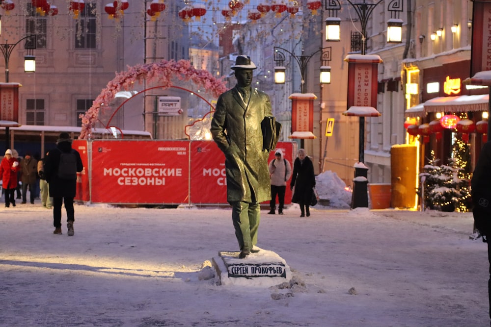 uma estátua de um homem em pé na neve