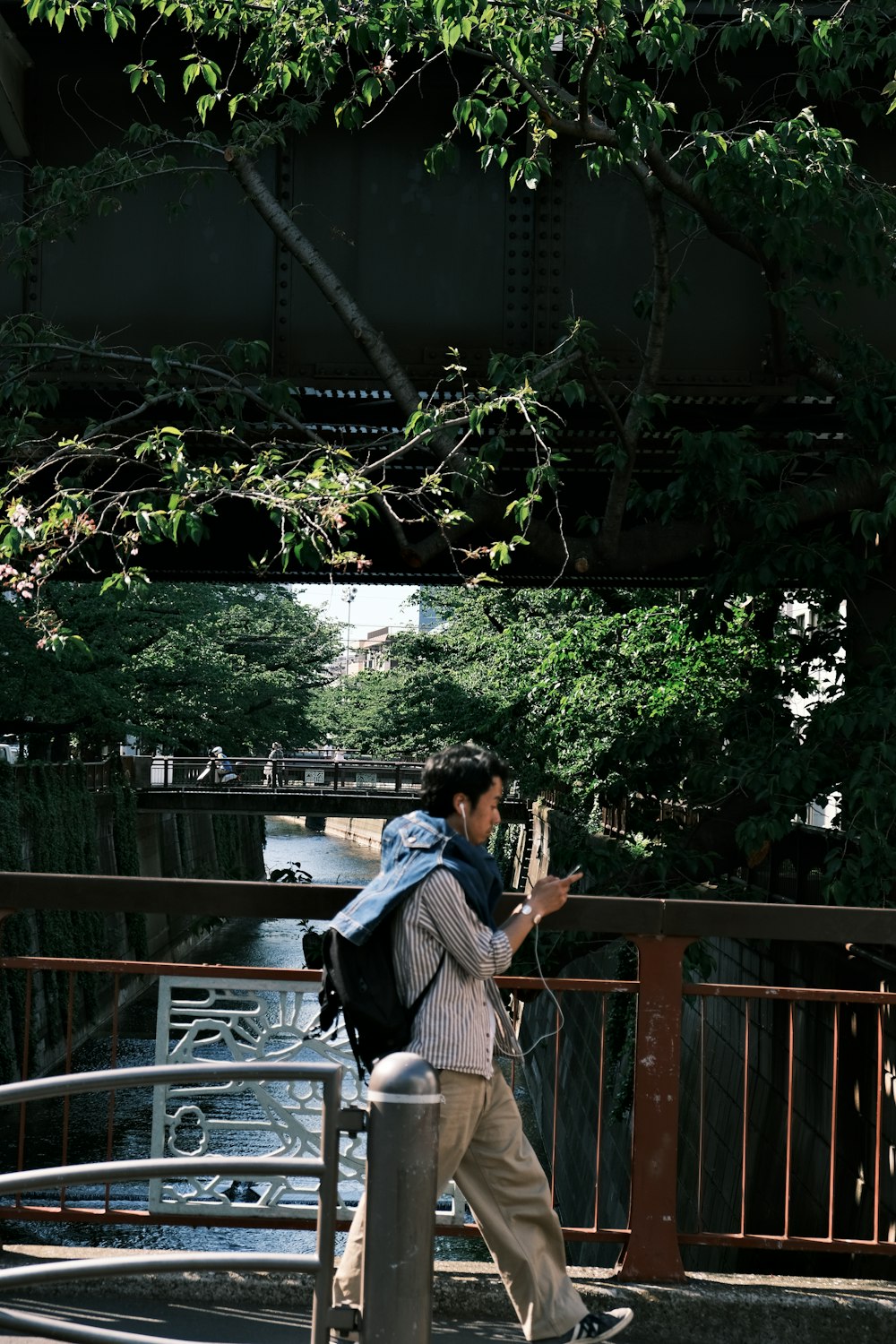 a man with a backpack walking across a bridge