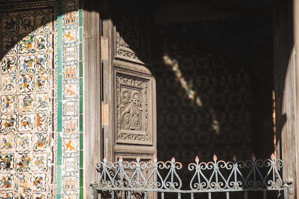 um portão de ferro forjado com uma parede decorativa atrás dele