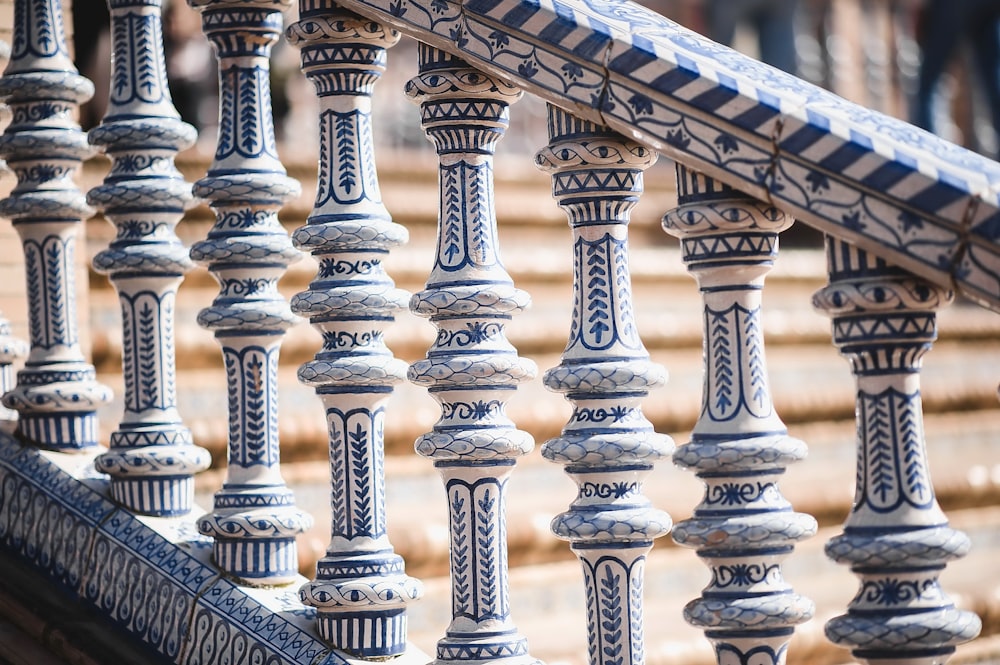 a close up of a metal railing with blue and white designs