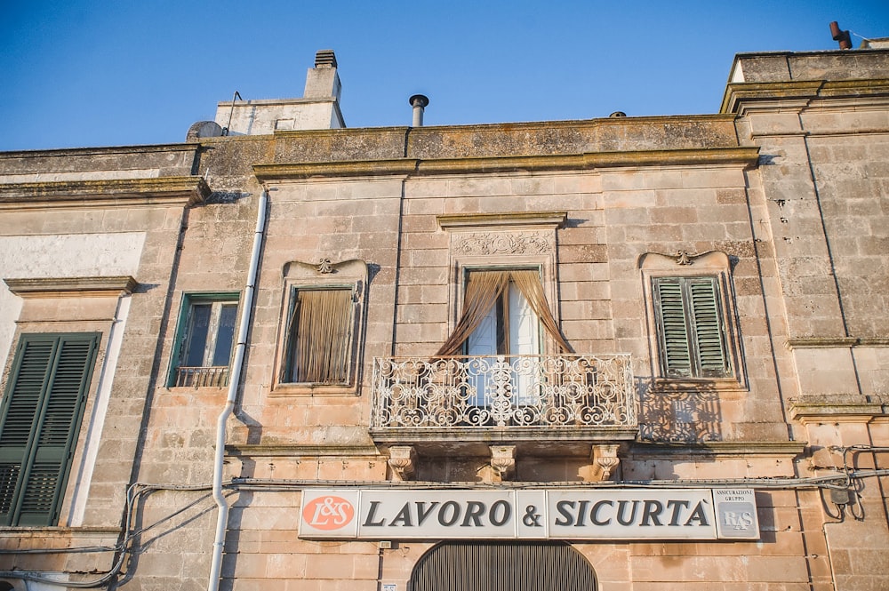 an old building with a balcony and a sign that says lavoro and sic