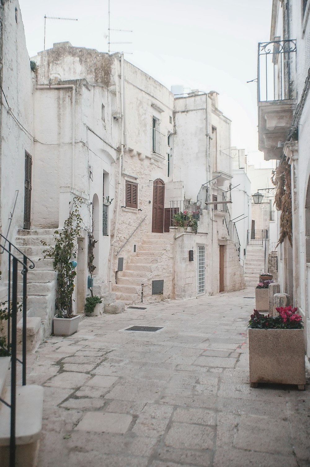 a cobblestone street lined with white buildings