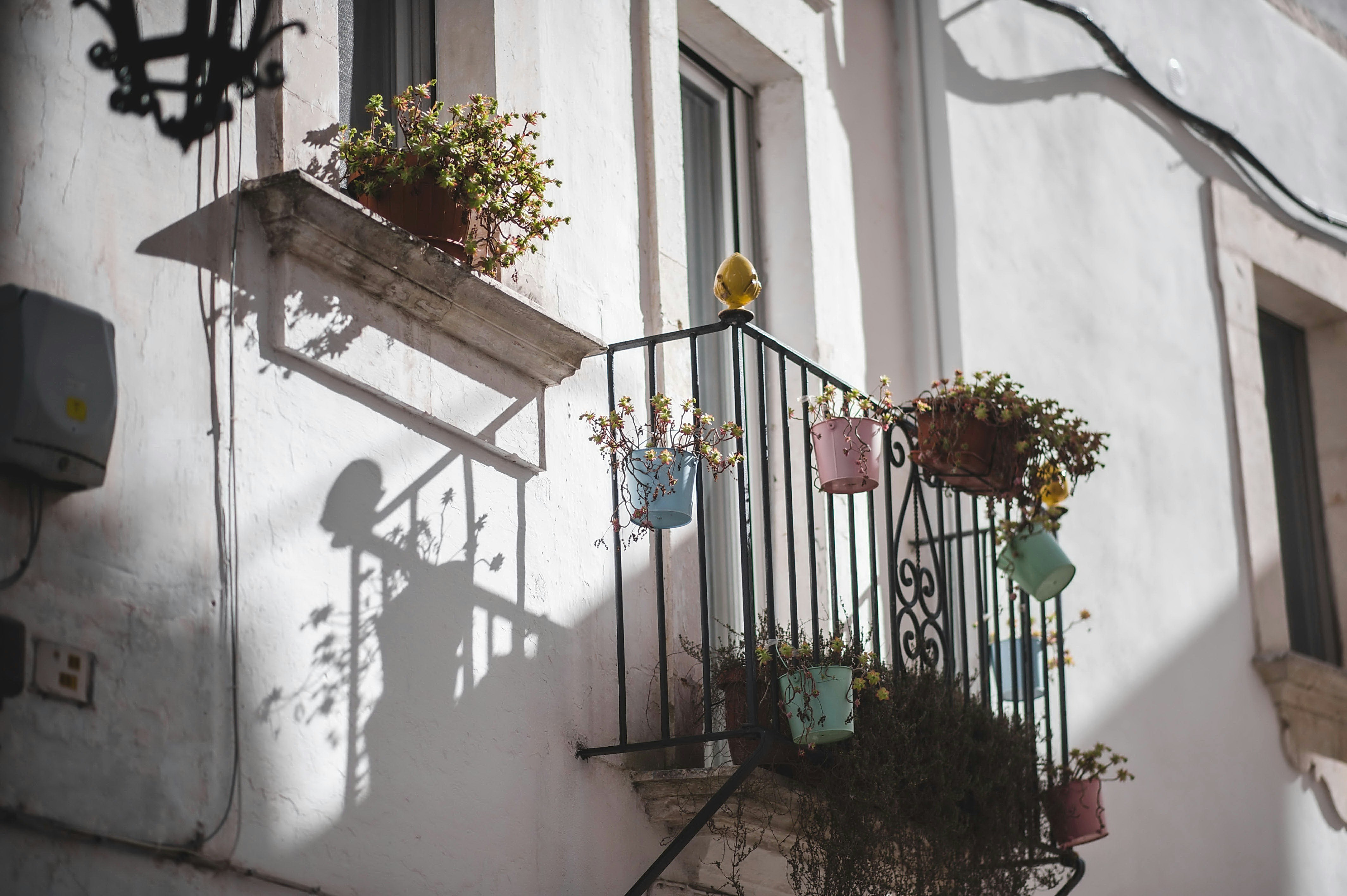 a balcony with a wrought iron railing and flower pots