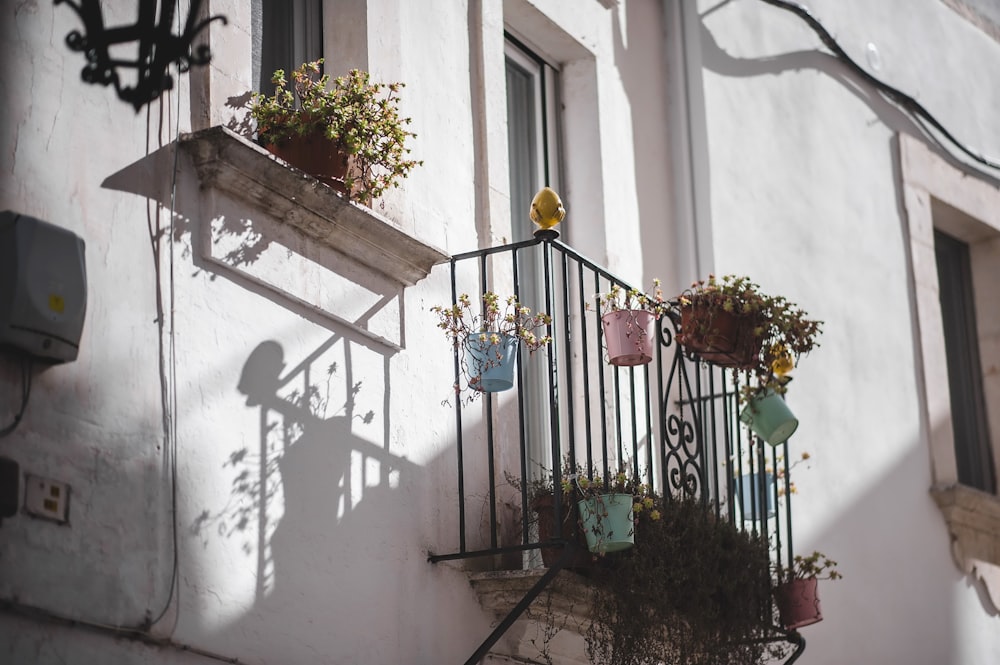 a balcony with a wrought iron railing and flower pots