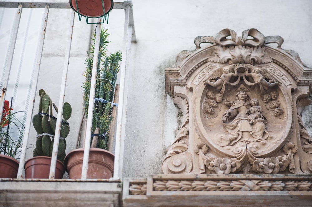 a statue of a woman on a balcony with potted plants