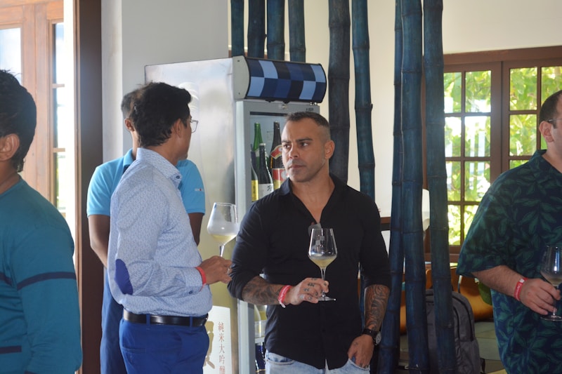 a group of men standing around each other holding wine glasses