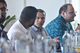 a group of men sitting next to each other at a table