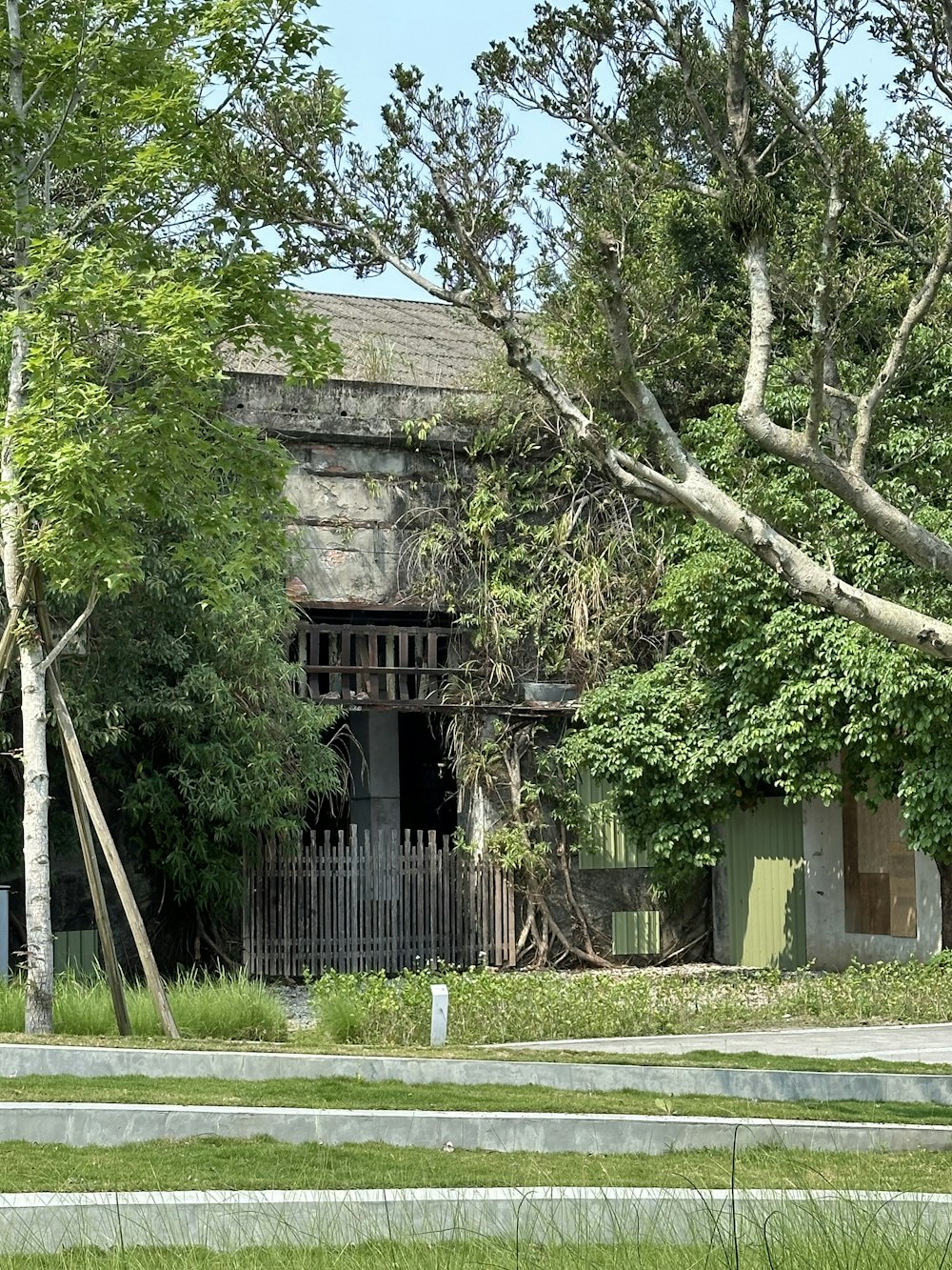 an old building with a fence and trees in front of it