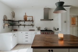 a kitchen with a wooden counter top next to a stove top oven