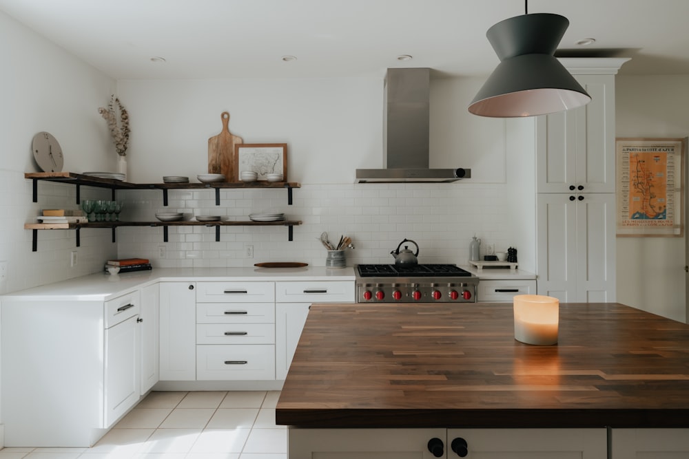 uma cozinha com uma bancada de madeira ao lado de um forno com placa de fogão