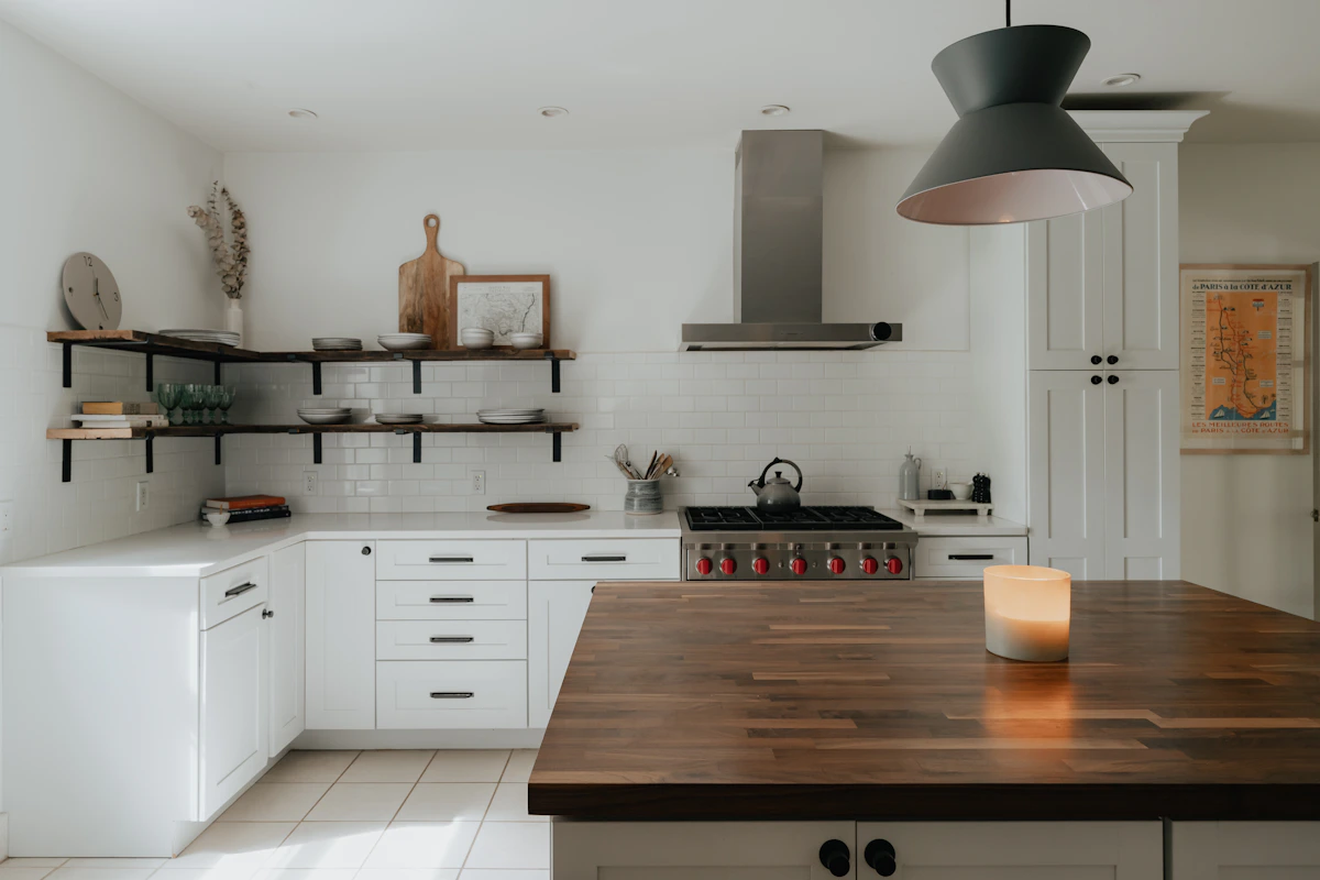 Cocina amplia con isla central fabricada con tablas de gran formato sin juntas visibles