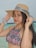 a woman in a bikini and a hat on the beach