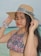 a woman in a bikini and a hat on the beach