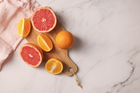 a cutting board with grapefruits and oranges on it