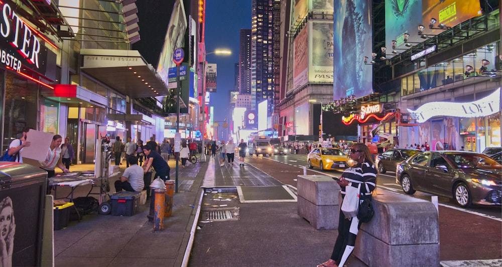 a busy city street at night with people and cars