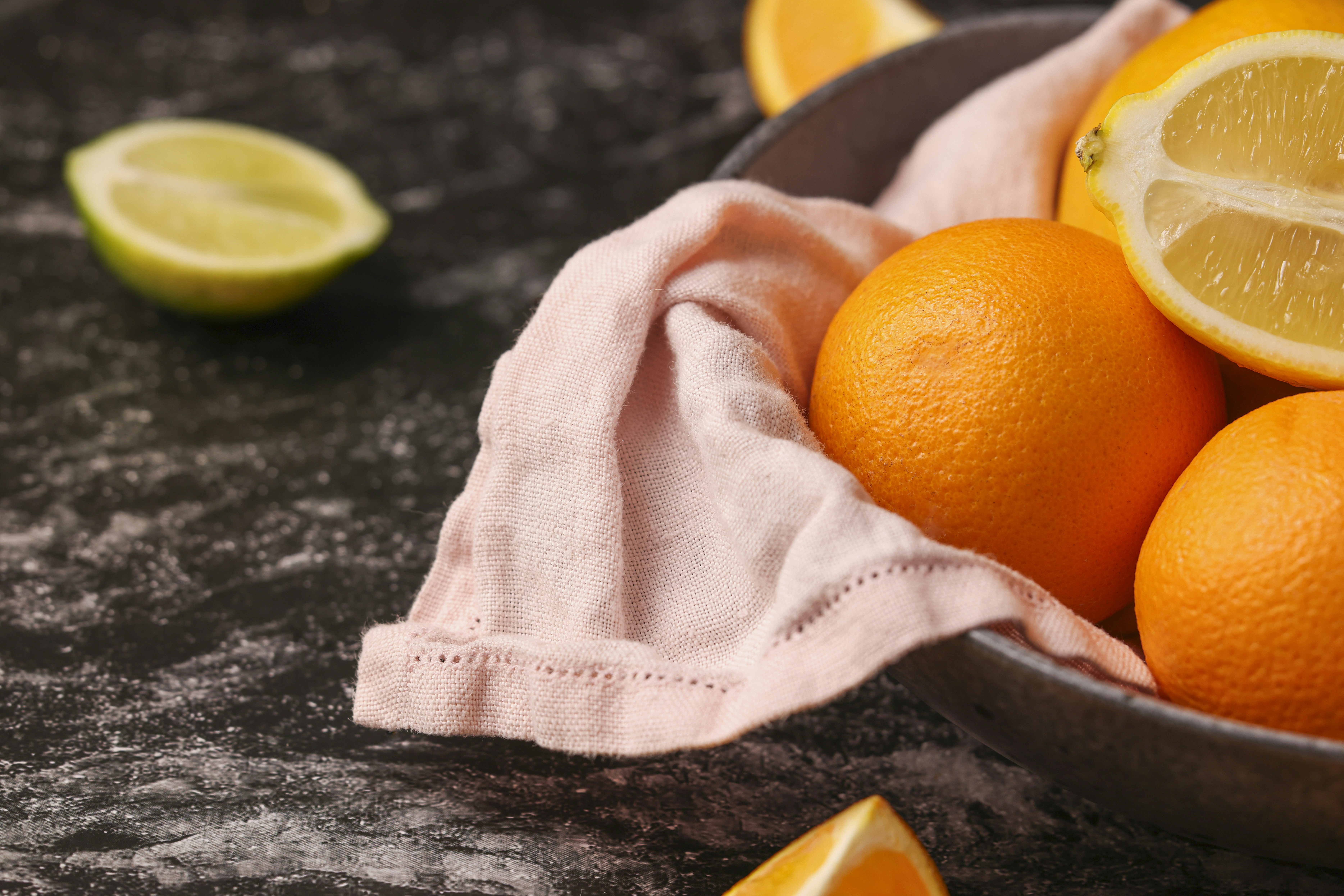 a bowl filled with oranges and limes on top of a table