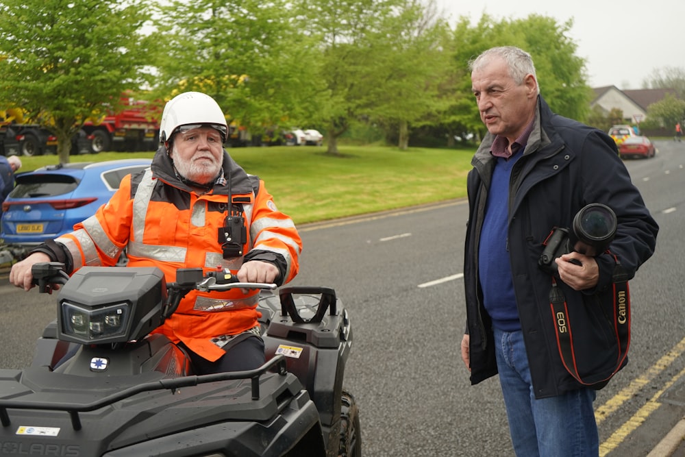 a man in an orange jacket and a man in an orange jacket standing next to