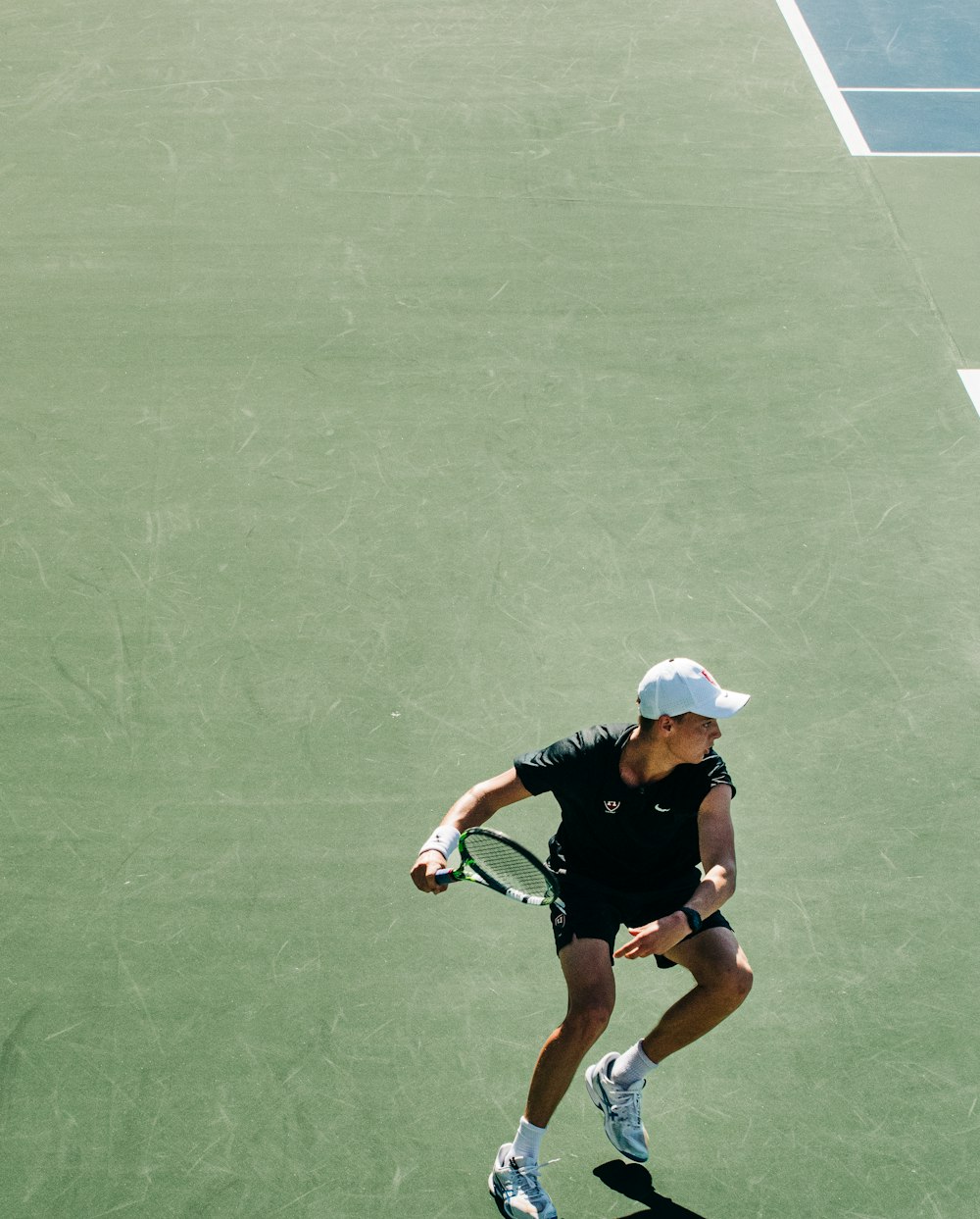 eine Frau hält einen Tennisschläger auf einem Tennisplatz