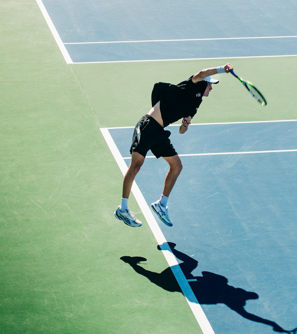 테니스 코트에서 테니스 라켓을 휘두르는 남자