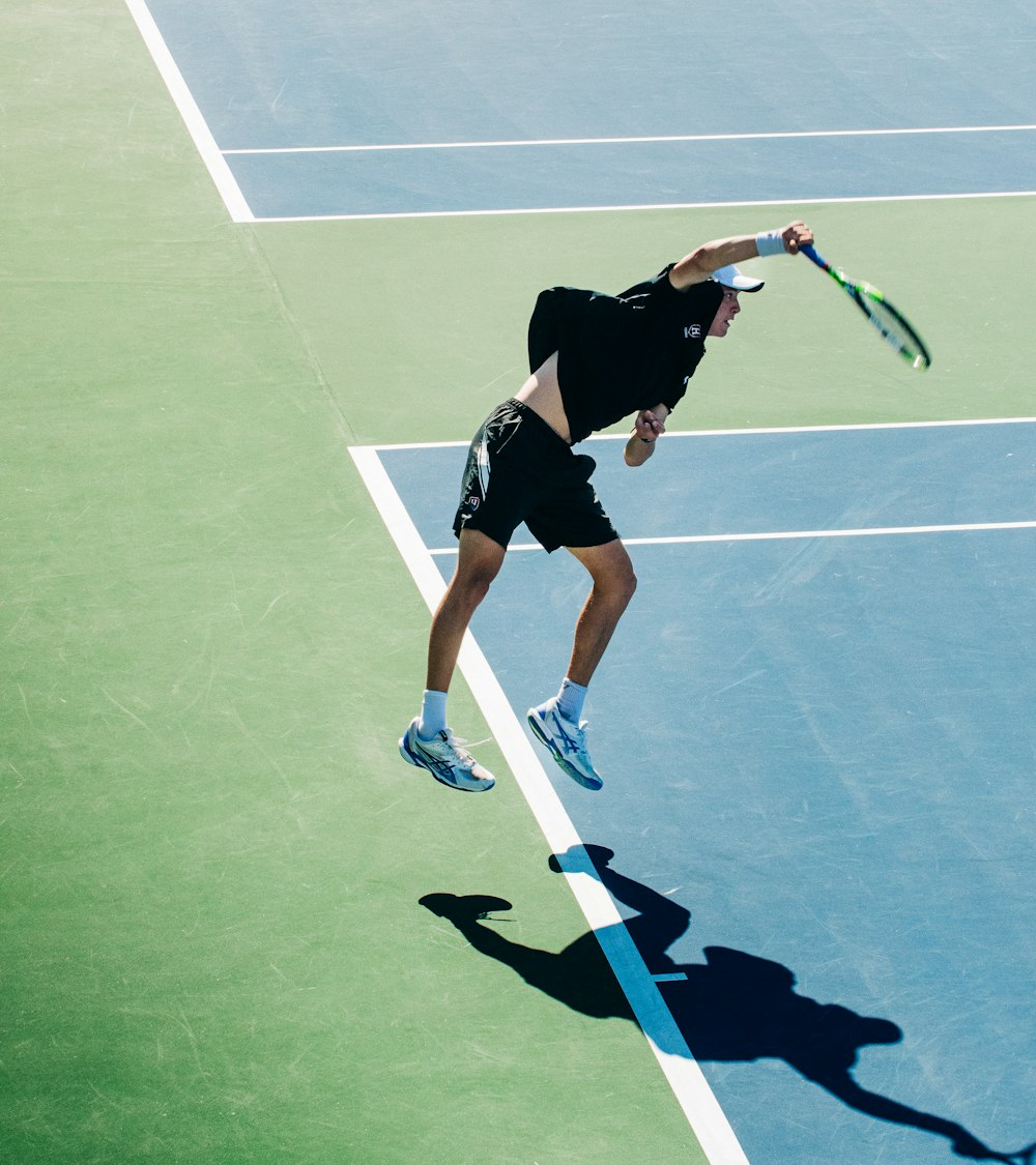 a man swinging a tennis racquet on a tennis court