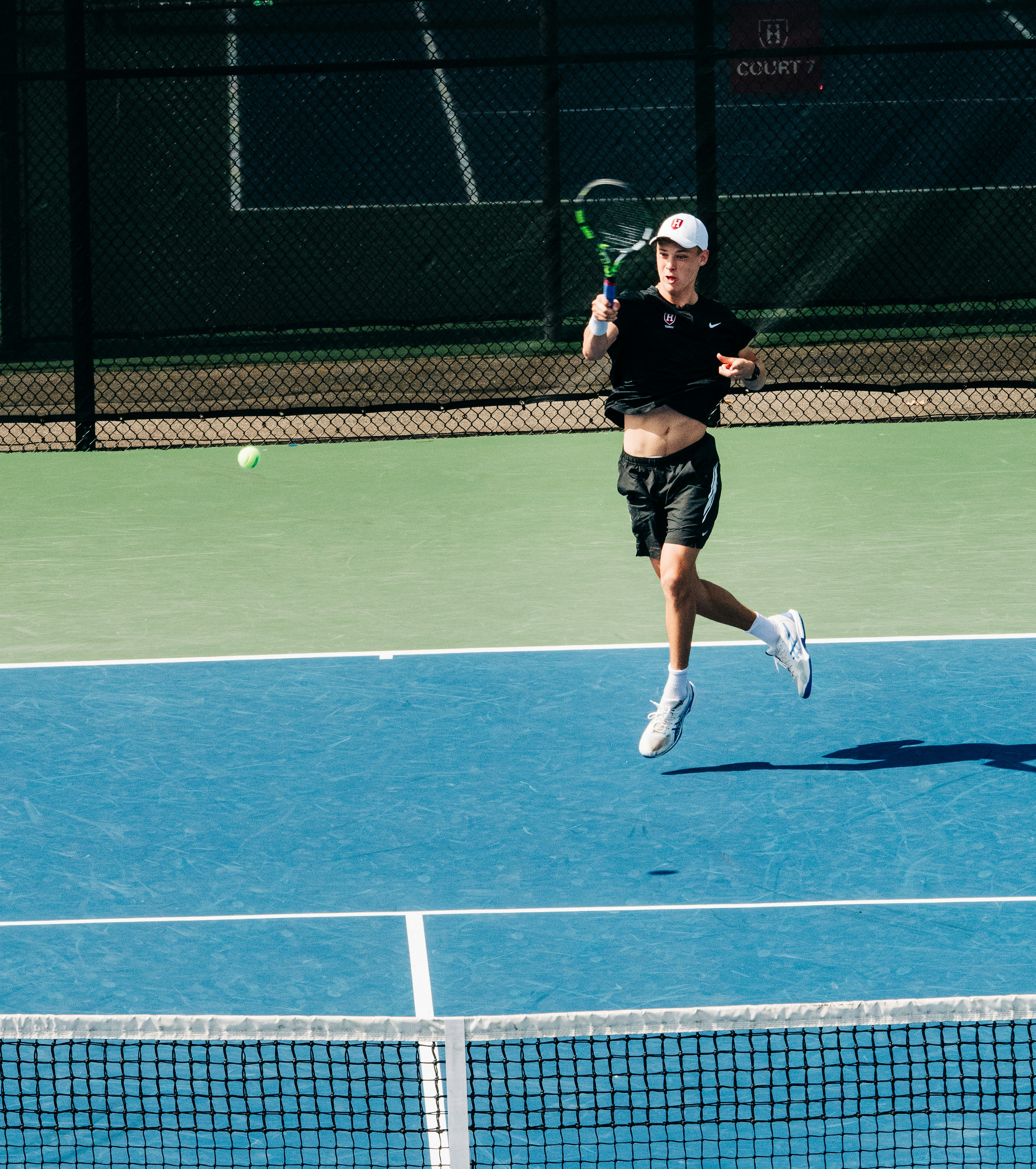 a man running across a tennis court holding a racquet
