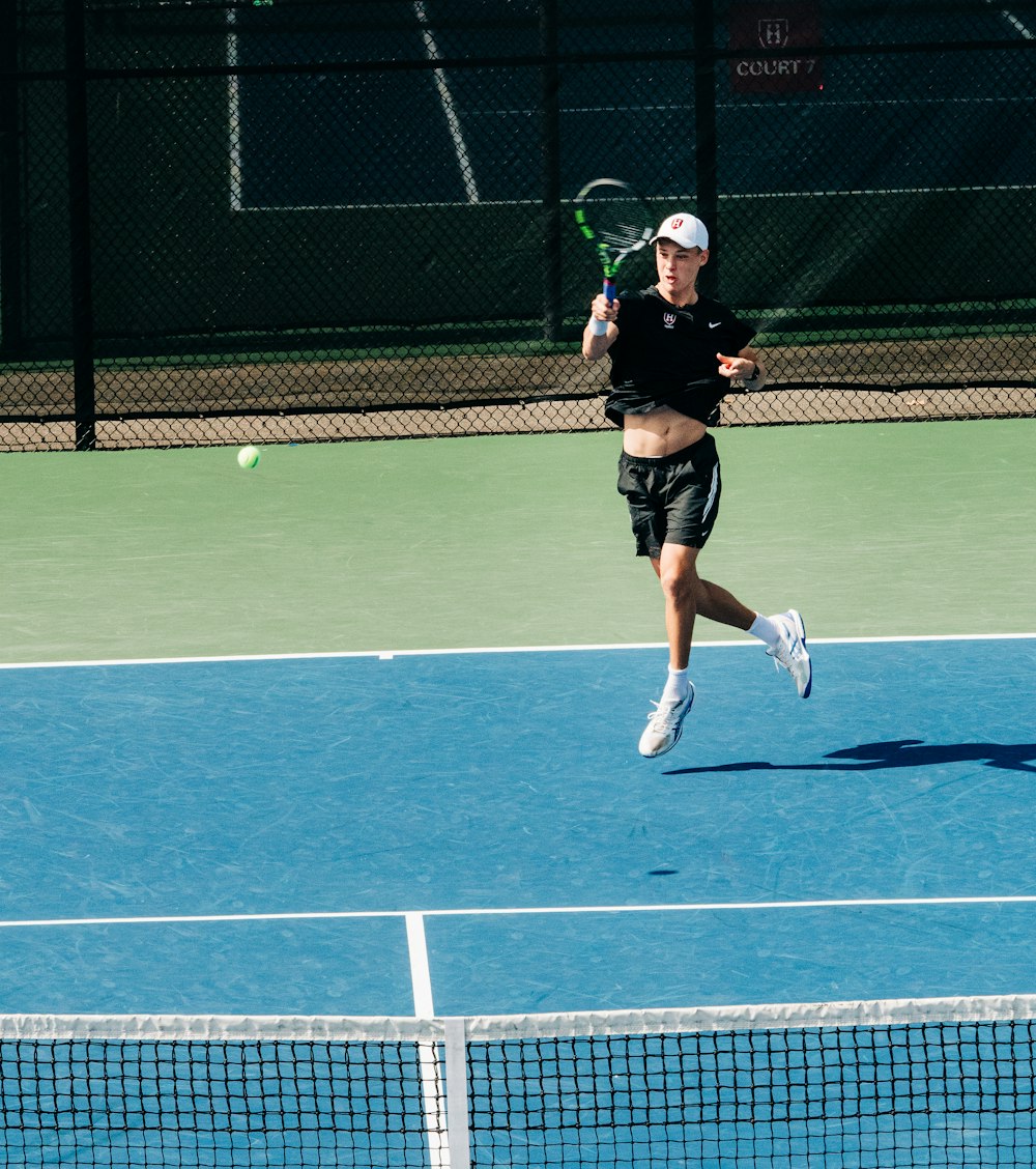 a man running across a tennis court holding a racquet