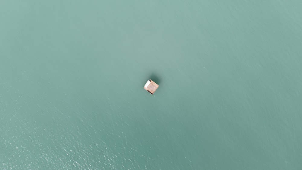 a small boat floating in the middle of a body of water
