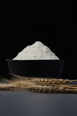 a bowl of flour sitting on top of a table