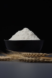 a bowl of flour sitting on top of a table