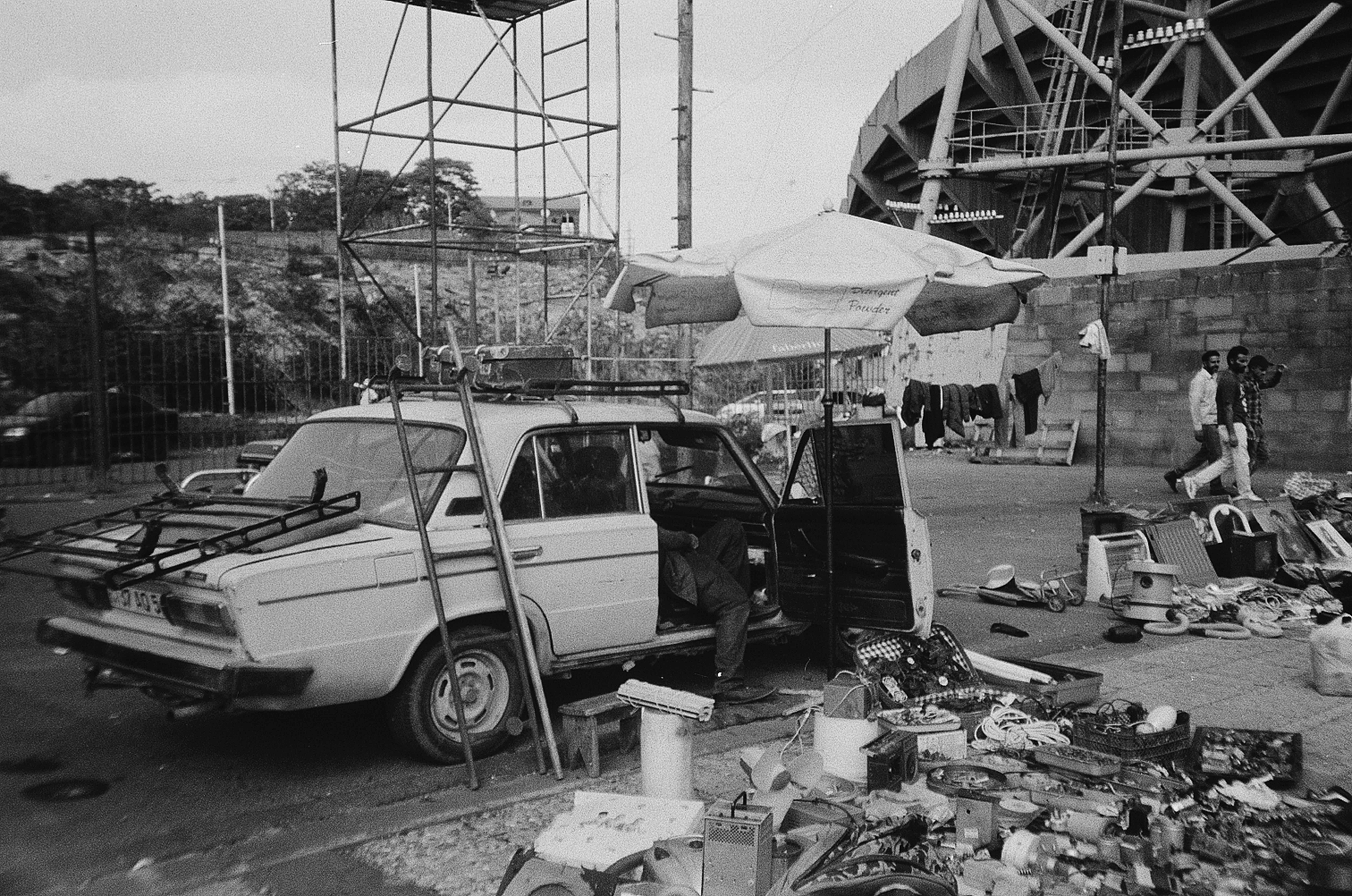 a white car parked next to a pile of junk
