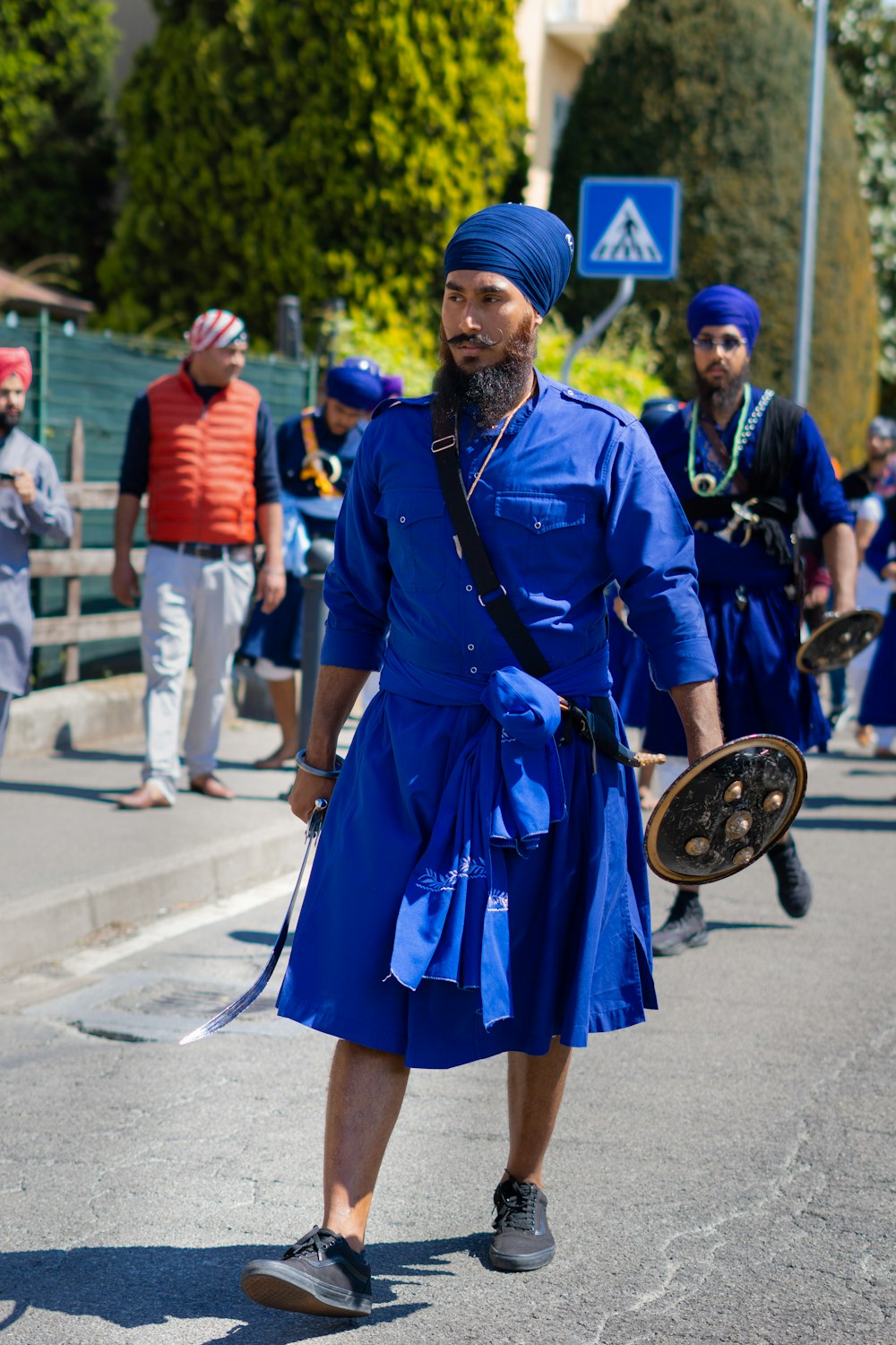 a man in a blue outfit walking down the street