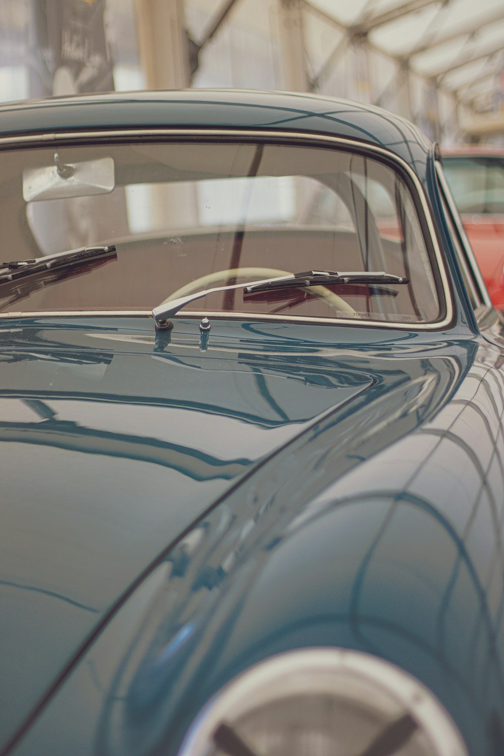 an old blue car parked in a garage