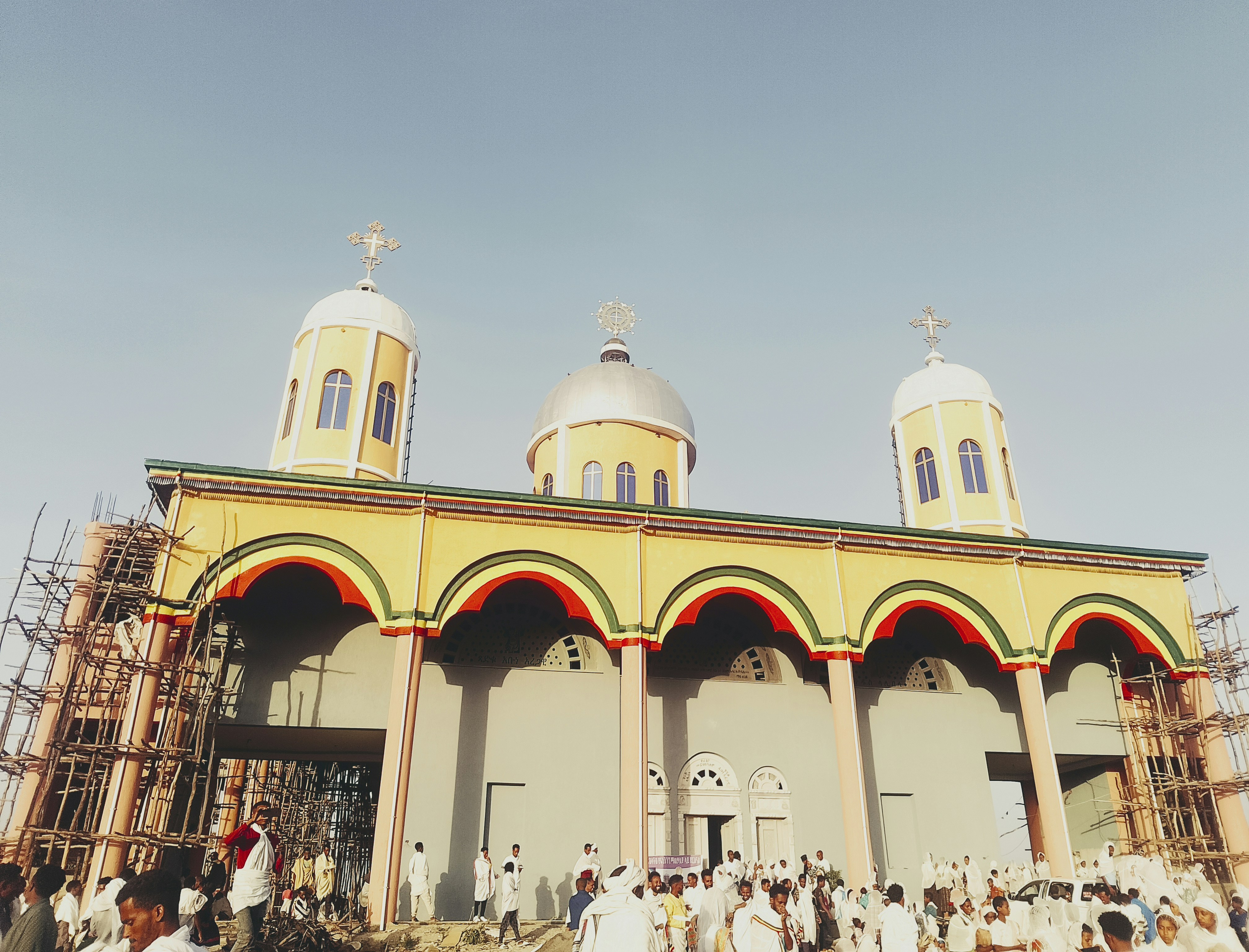 Ethiopian community gathering outdoors, traditional attire, warm afternoon light
