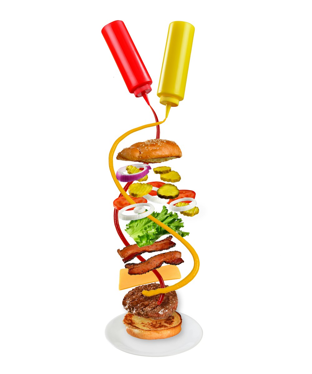 a hamburger with ketchup, mustard, lettuce, tomatoes, and