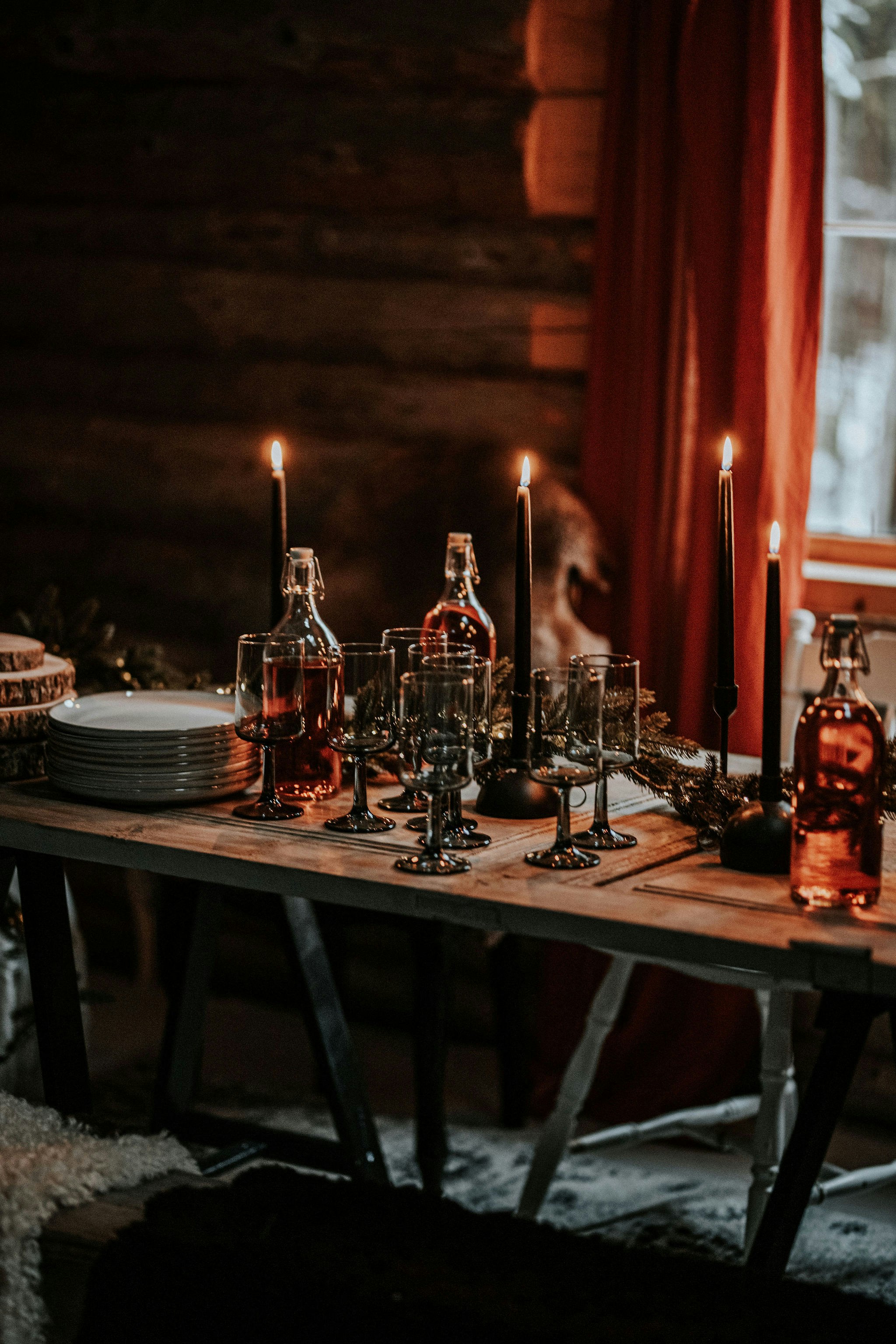 a wooden table topped with lots of bottles and candles