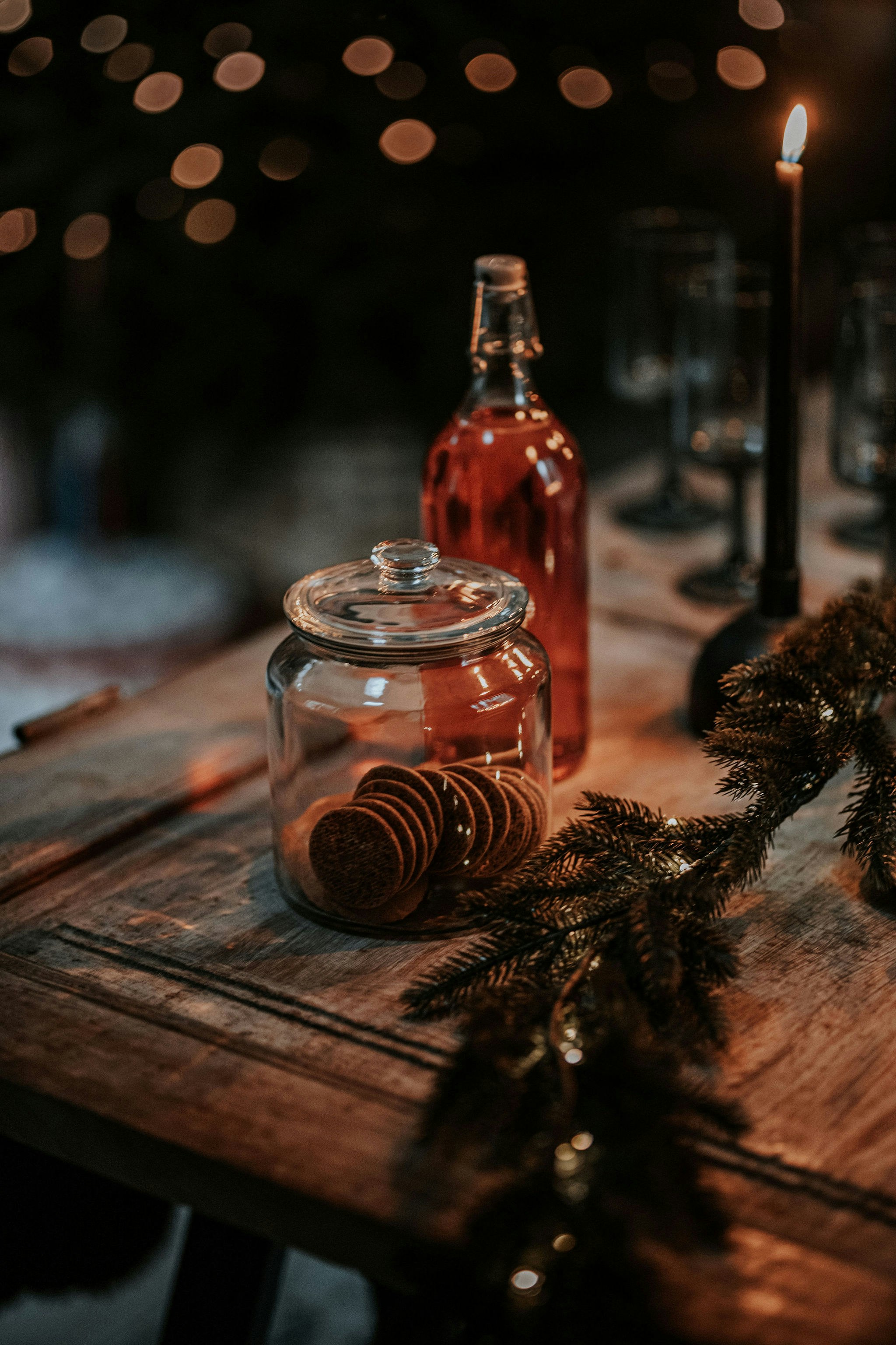 a wooden table topped with a jar filled with candles