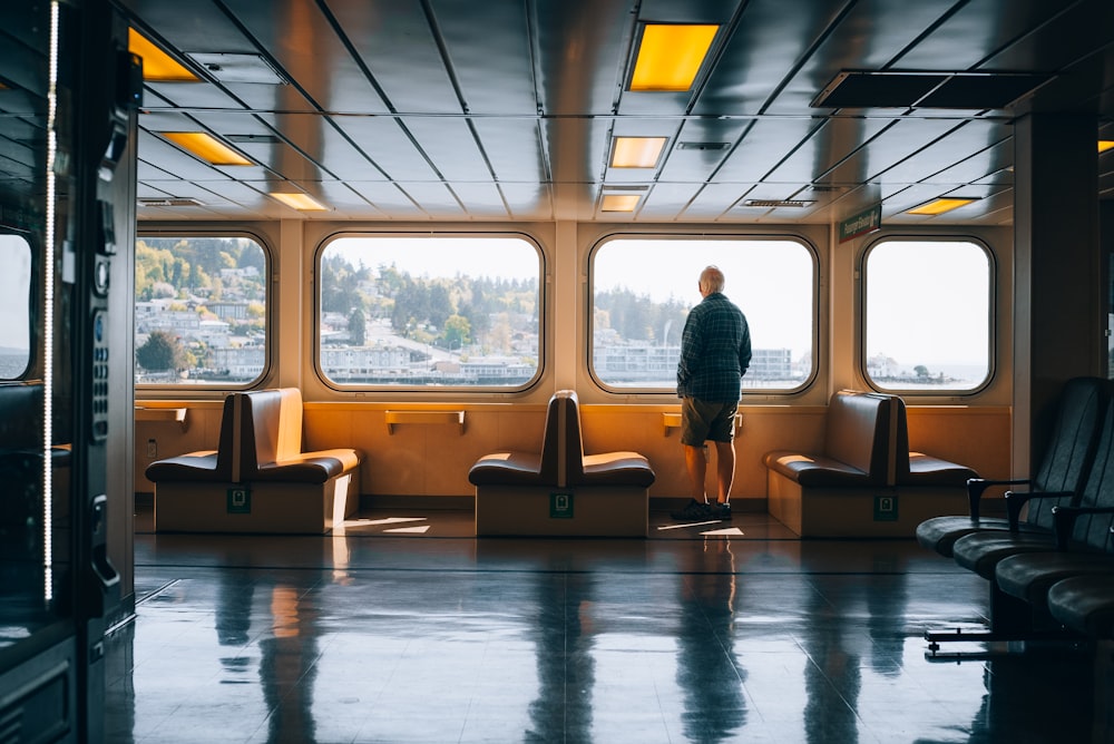 a man standing on a boat looking out the window