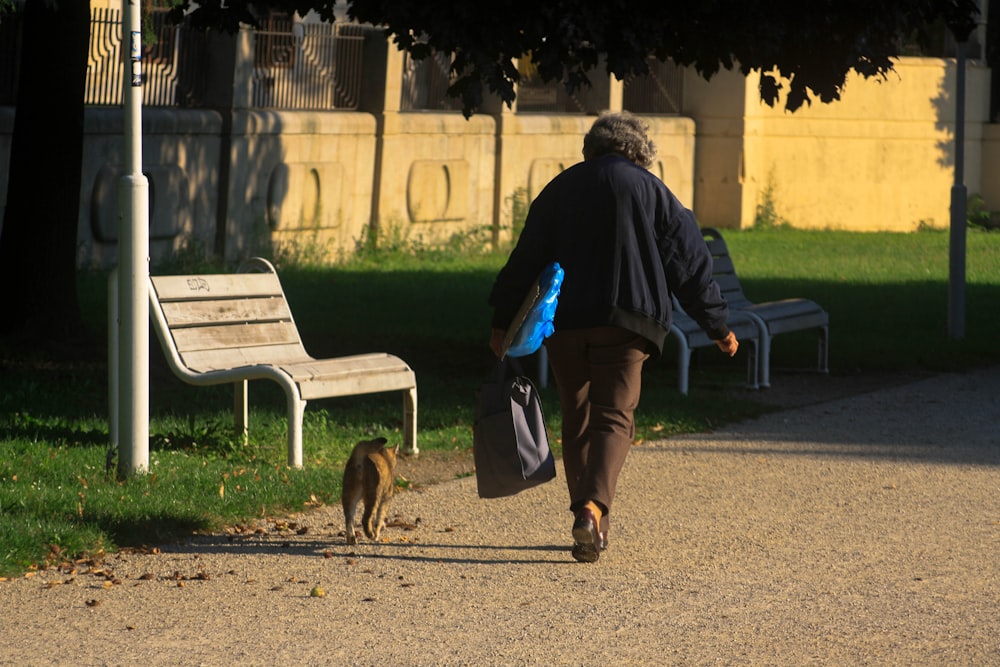 a person walking down a path with a dog