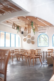 a restaurant with tables, chairs and hanging baskets