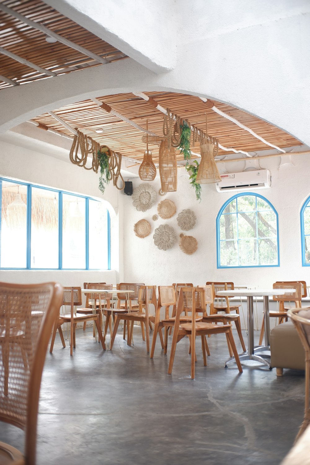 a restaurant with tables, chairs and hanging baskets