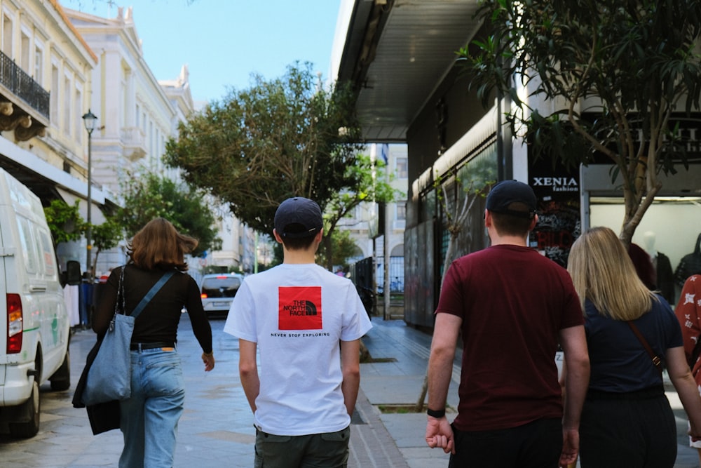 a group of people walking down a sidewalk
