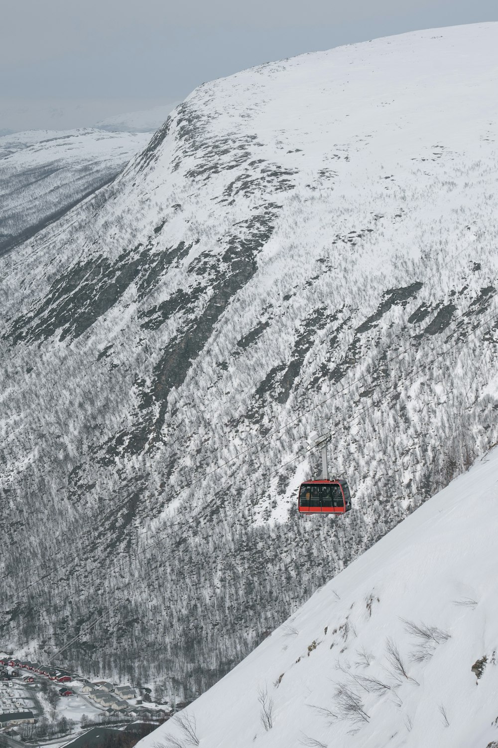 a red bus traveling down a snow covered mountain