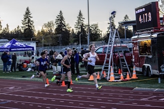 a couple of people that are running on a track