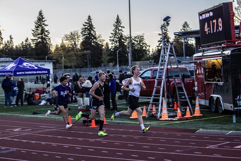 a couple of people that are running on a track