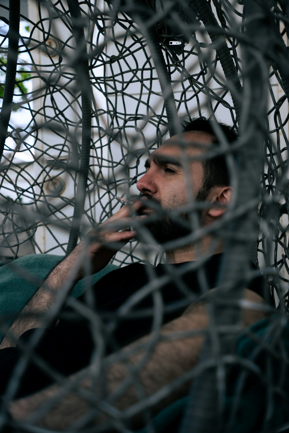 a man sitting in a chair behind a net