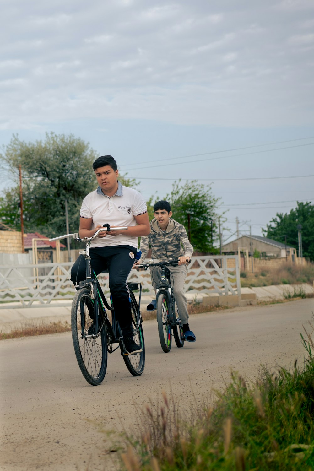 a man riding a bike next to a boy on a cell phone