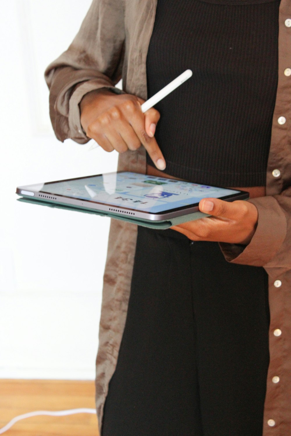 a person holding a tablet and a pen